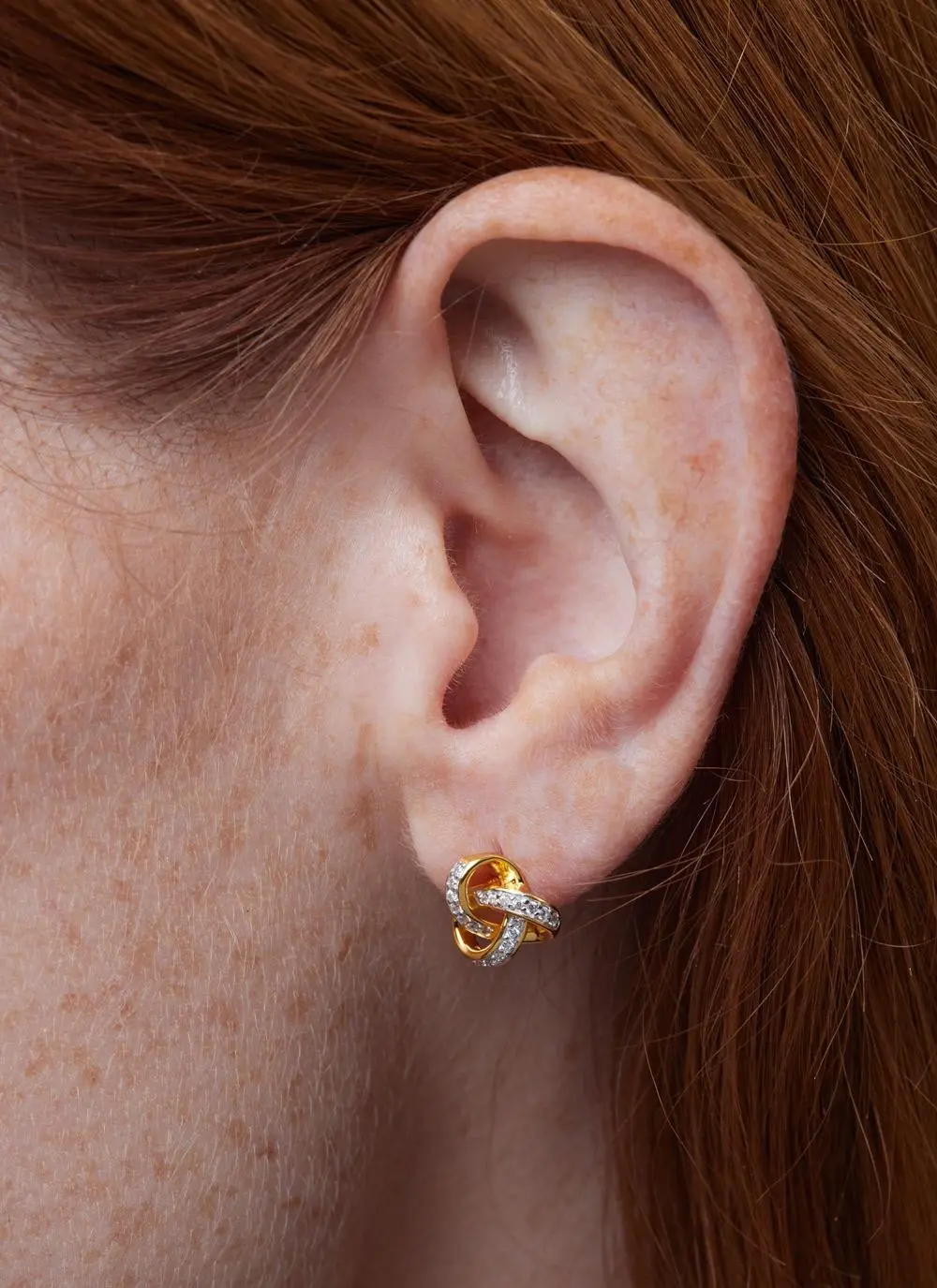 Close up shot of red haired model wearing 14ct Gold Vermeil Trinity Knot Stud Earrings with Cubic Zirconia